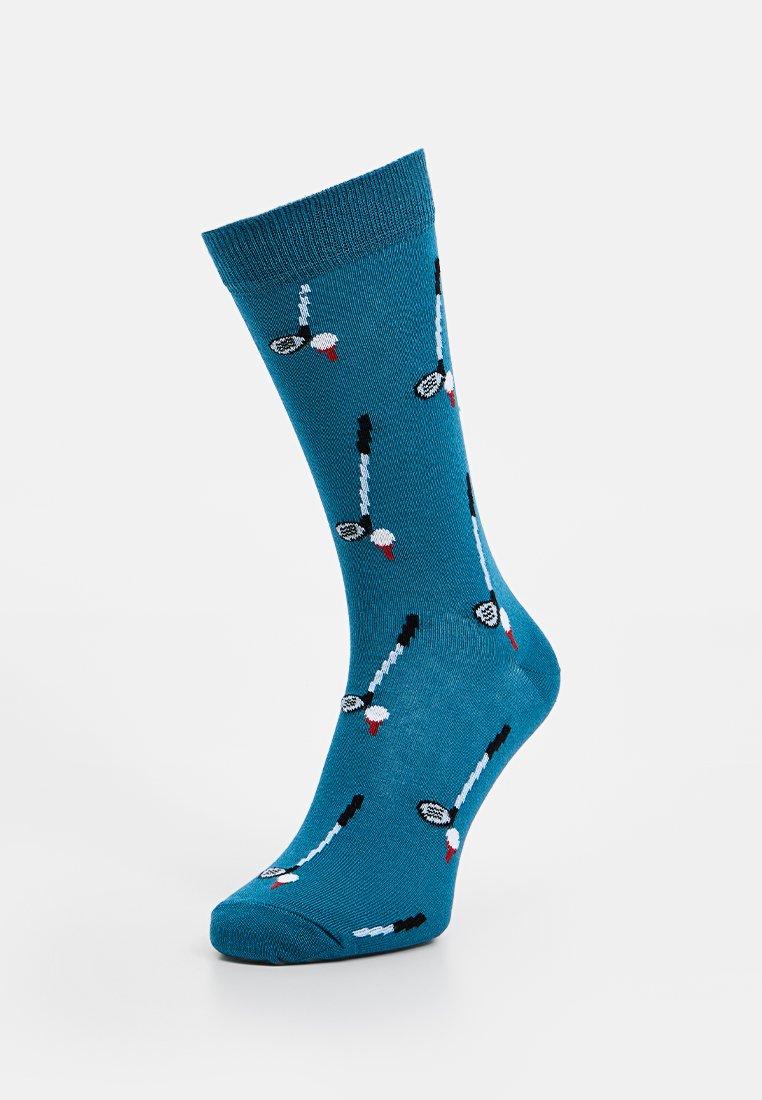 Türkise Socken mit einem Muster aus schwarzen und weißen Badmintonschlägern mit roten Akzenten. Strickstoff, mittlere Höhe bis zur Wade, glatte Textur.