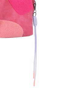 Borsa in suede rosa con pannelli testurizzati in fucsia e rosa pastello. Include una sottile tracolla intrecciata in viola chiaro con estremità rosa.
