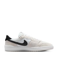 Λευκό και μπεζ αθλητικό παπούτσι Nike χαμηλού προφίλ με μαύρο λογότυπο Swoosh και λευκή σόλα, εμφανίζεται από το πλάι σε λευκό φόντο.