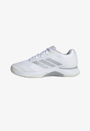 Zapato deportivo blanco con parte superior de malla y tres franjas grises. Punta redondeada y suela texturizada para mayor agarre. Diseño con cordones y collar acolchado.