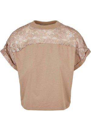 Lyhythihainen T-paita vaaleanbeigeväri, jossa on pitsipaneeli hartioilla. Suorastaan pehmeä kangas ja rento malli.