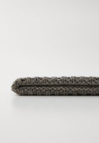 Textile en tricot gris, présentant un motif texturé, avec deux sections pliées. Le matériau semble doux et durable.