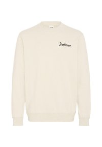 Sweat-shirt beige clair à manches longues, col rond, avec un discret logo "Soulscape" en lettres foncées sur le côté gauche de la poitrine. Tissu texturé.