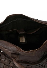 Borsa a mano in pelle marrone con trama intrecciata, chiusura con zip e tasca interna. Presenta un'etichetta con la scritta "HARBOUR" e un motivo di ancora. Fodera nera.