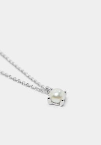 Collana d'argento con un pendente in perla bianca rotonda, dotato di una montatura a quattro artigli e una catena texturizzata. Design semplice ed elegante.