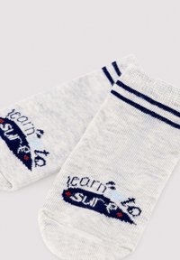 Par de calcetines tobilleros gris claro con dobles rayas azul marino en los puños y texto bordado "learn to surf" con diseño.