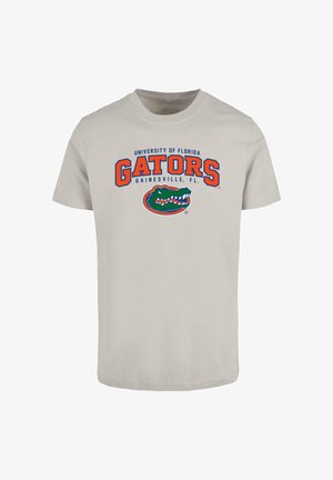 Világosszürke pamut póló rövid ujjakkal. A pólón kék és narancssárga betűkkel szerepel a "University of Florida GATORS" felirat, valamint egy alligátor grafika.