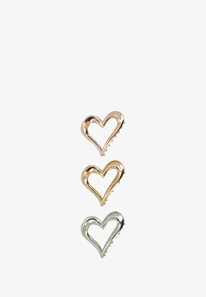 Tre fermagli per capelli a forma di cuore in oro rosa, oro e argento. Ognuno presenta un design aperto con grip testurizzati sul lato inferiore.