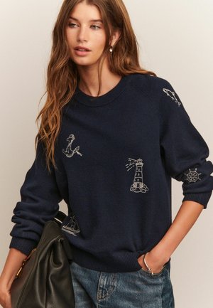 Sweatshirt de culoare bleumarin închis, cu designuri nautice brodate, inclusiv un ancora, un far, pește și o barcă cu vele. Manșete și tiv cu nervuri.