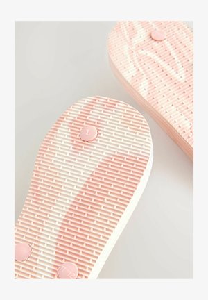 Rózsaszín, textúrált talpbetétek ívelt formával, barázdált mintával, bal lábhoz „L” jelöléssel, alatta sima fehér talp.