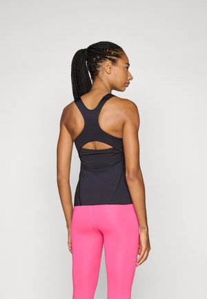 Black athletic tank top with racerback design and cutout detail at the back, paired with fitted pink leggings. Smooth, stretchy fabric.