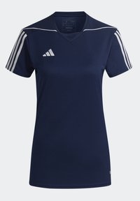 Tummansininen urheilupaita, joka on valmistettu kevyestä kankaasta. Siinä on v-pääntie, kolme valkoista raitaa kummallakin olkapäällä ja kirjailtu logo.