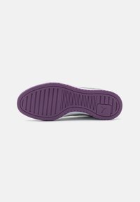 Suola della scarpa in gomma viola con distintivi solchi orizzontali e verticali per la trazione; parte posteriore arrotondata e logo impresso di lato.