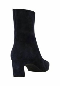 Donkerblauwe suède enkellaars met blokhak, gladde textuur, afgeronde neus en aansluitende schacht, ontworpen voor een strakke pasvorm rond de enkel.