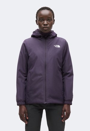 Person iført en mørkelilla hættetrøje med forlynlås og hvid The North Face-logo på brystet foran en ensfarvet baggrund.
