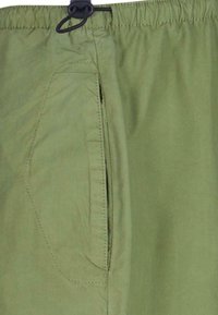 Lysegrønne shorts med elastisk liv og snøre. Har en sidelomme med en subtil skrå sømdetalj. Glatt tekstur.
