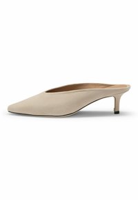 Beige suede mules with a pointed toe, low heel, and an open back. Features a thin black trim along the sole and a gold accent on the heel.