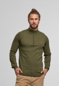 Grüner Reißverschluss-Pullover mit hohem Kragen, aus einem glatten Stoff gefertigt, mit einem dezenten Logo auf der Brust sowie gerippten Bündchen und Saum.