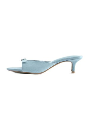 Mule en suède bleu clair à bout ouvert, à petit talon kitten et avec une petite boucle sur la bride supérieure.