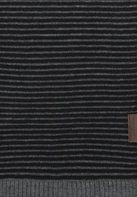 Szaro-czarny, paskowany dzianinowy materiał o prążkowanej teksturze. Zawiera skórzaną metkę z napisem "LANGE" subtelnie przyszytą blisko dolnej krawędzi.