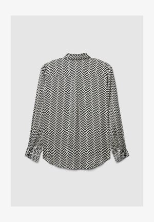 Chemise à manches longues avec un motif en zigzag blanc et noir, dotée d'un col, de poignets boutonnés et d'un pli dans le dos pour faciliter les mouvements.