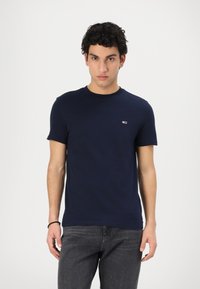 T-shirt in cotone blu navy con maniche corte e collo rotondo, caratterizzato da un piccolo logo sul petto e una superficie liscia.