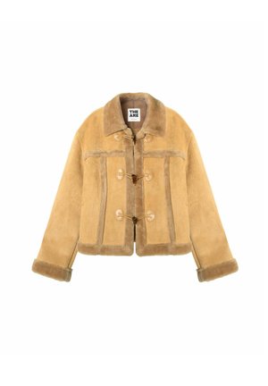 Veste en peau lainée beige avec fermetures à bascule, col large et manches retroussées, présentée sur un fond blanc.