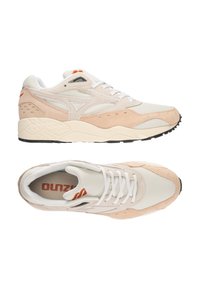 Baskets légères avec une tige en suède et mesh beige et pêche, lacets blancs et une semelle en caoutchouc texturée avec des accents noirs.