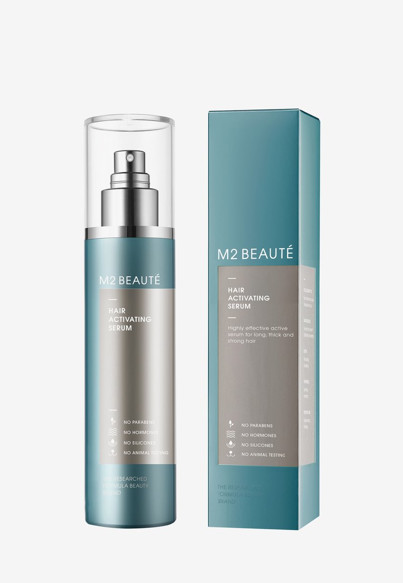 Serum aktywujące włosy w cylindrycznej szklanej butelce z srebrną pompką, w niebieskim i srebrnym opakowaniu z informacjami o produkcie oraz bez ikon symbolicznych.