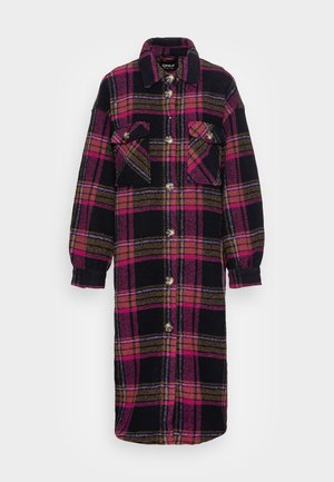 Manteau long à carreaux avec des tons noirs, roses et bruns, doté de deux poches à rabat sur la poitrine et de manches longues avec poignets.