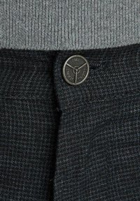 Ciemnoniebieska, fakturowana tkanina w kratę. Posiada okrągły, czarny metalowy guzik z napisem "PME Legend Jeans". Elastyczny, szary pas z ryflem na górze.