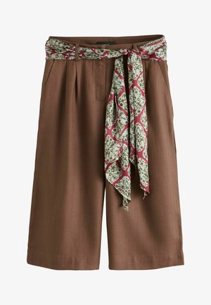 Hnedé široké šortky s prednými záhybmi a bočnými vreckami, s opaskom z látky s kvetinovým vzorom, ktorý je uviazaný na mašľu v páse.