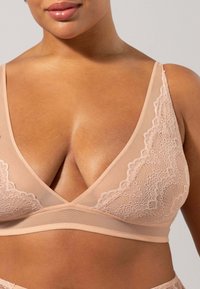 Nud bralette med spetsdetaljer och meshpaneler, med en djup V-ringning, mjuk textur och utan byglar för flexibel support.