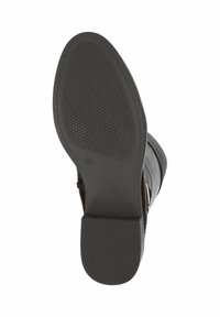 Suela de bota negra con goma texturizada para agarre, con un leve tacón y bordes lisos. Marcada con la talla "4½."