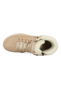 Tan suede enklaars met zachte witte faux fur voering, vetersluiting en een gevoerde kraag voor warmte en comfort.