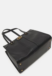 Sort læder tote bag med to skulderremme, guld hardware detaljer og en struktureret form. Bemærkelsesværdig tekstureret finish og fire ben på bunden.
