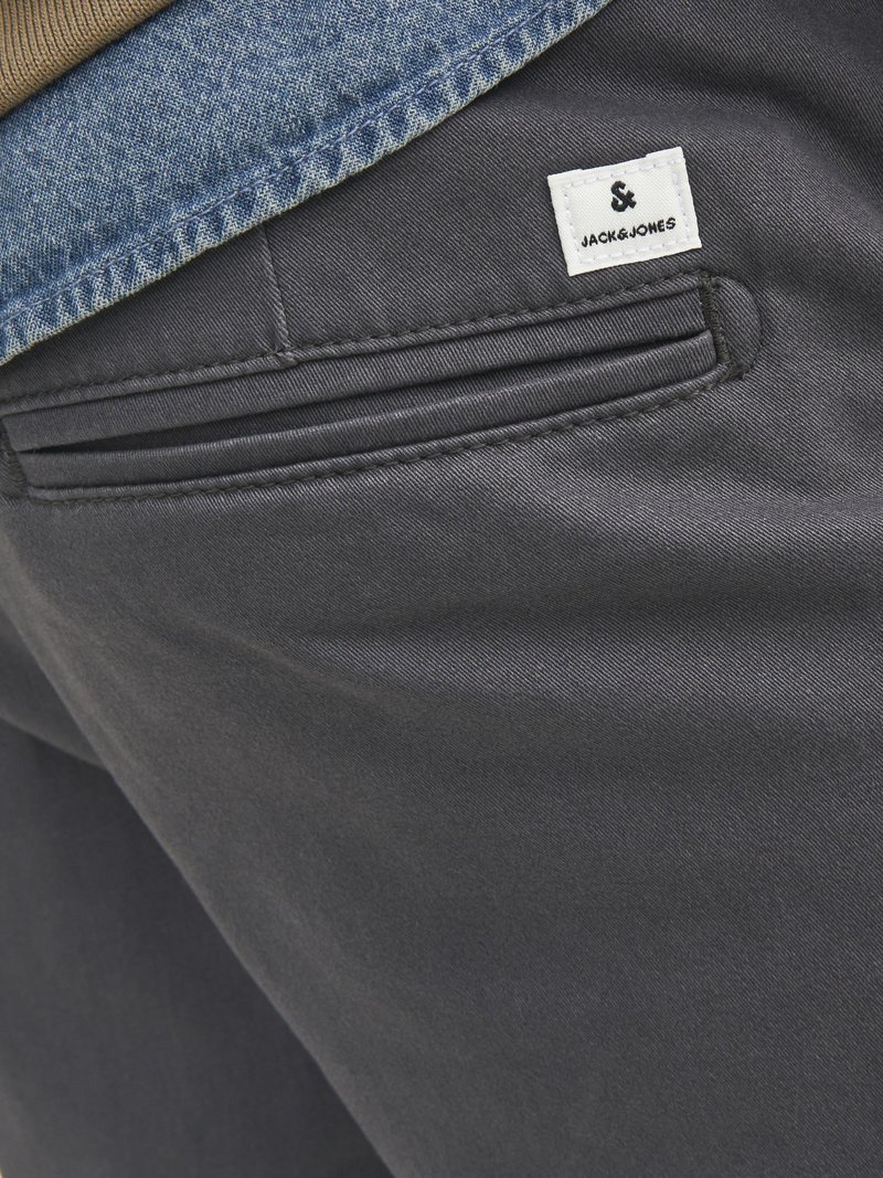Dunkelgraue Hose mit einem eleganten Design, Details an den Fronttaschen und einem weißen Markentag, kombiniert mit einem Denim-Oberkant.