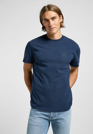 T-shirt in cotone blu navy con colletto rotondo, maniche corte e taschino sul lato sinistro del petto. Presenta un piccolo logo sopra la tasca.