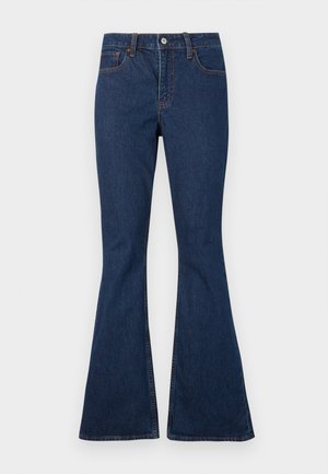 Σκούρο μπλε τζιν με εφαρμοστή μέση και καμπυλωτά μπατζάκια, με μπροστινές τσέπες και εμφανείς ραφές σε αντίθεση.