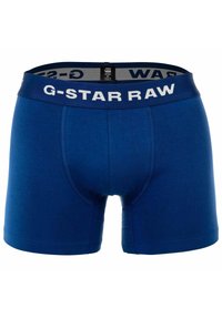 Boxers de algodón azul con una cinturilla blanca "G-STAR RAW", que presentan un ajuste ceñido y una textura suave, adecuados para el uso diario.
