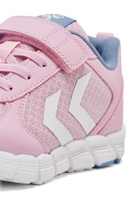 Rosa träningsskor med en texturerad ovandel, vitt kvadrantmönster, kardborreband och vit sula med subtila blå detaljer.