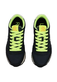 Sneaker da atletica blu navy con vivaci lacci verde neon, materiali in camoscio e mesh, dettagli bianchi sulla suola e testi motivazionali sulla linguetta.