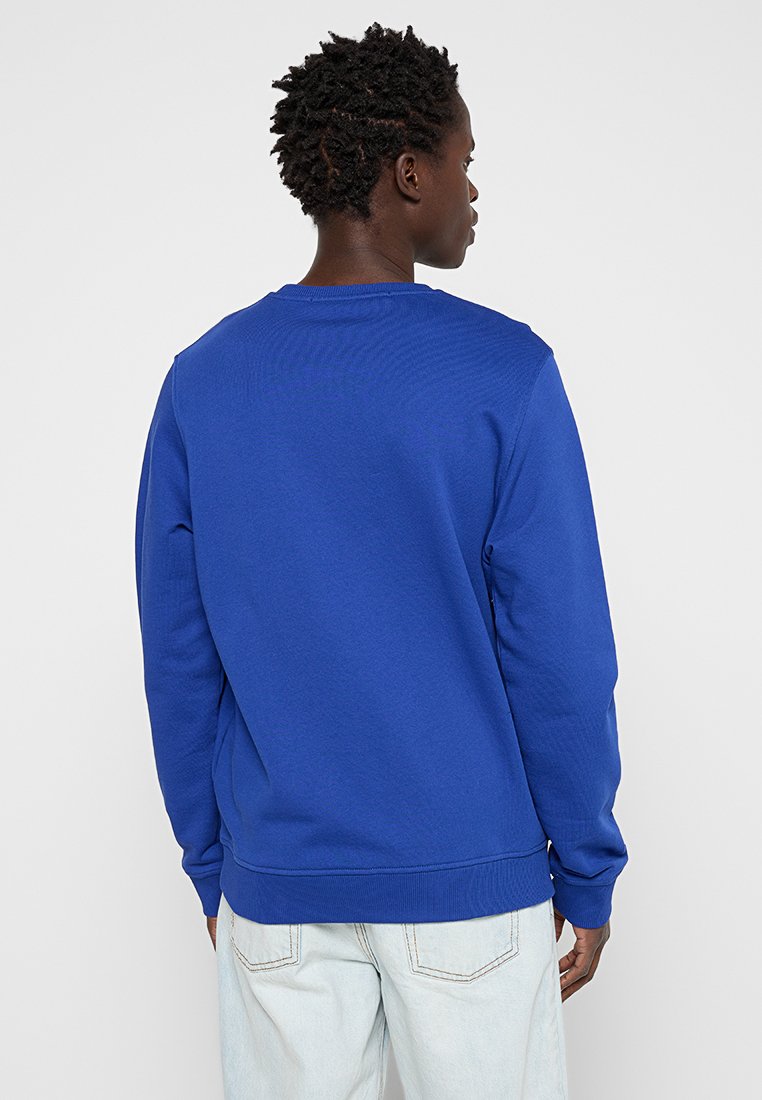 Sweatshirt col rond en bleu royal, avec des poignets et une ourlet côtelés, fabriqué dans un mélange de coton texturé avec une coupe décontractée.