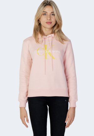 Sudadera ligera rosa hecha de tela suave, con un gran logotipo amarillo "CK" y texto blanco. Incluye capucha con cordón y puños acanalados.
