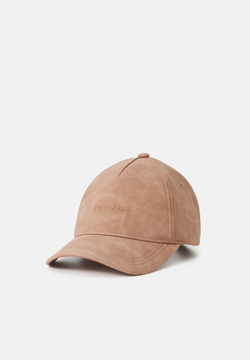 Căciulă de baseball din suede bej, cu o margine curbată și detalii cusute. Logo-ul Calvin Klein embosat pe față. Textură netedă.