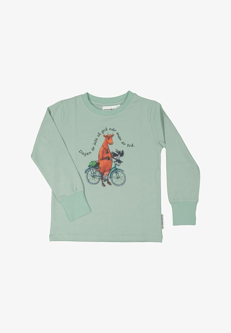 Myntr grønne langærmede skjorte med et grafisk motiv af en orange ko på en cykel med en fugl, samt tekst i et cirkulært mønster omkring det.