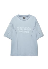 Svetle modré oversized tričko vyrobené z bavlny, s kulatým výstřihem, krátkými rukávy a bílým grafickým textem na přední straně s vyšívanými akcenty.