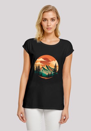 Schwarzes T-Shirt mit einem kreisförmigen Grafikdesign von Bergen, Sonne und Bäumen in Orange, Grün und Cremefarben. Lässiger, entspannter Schnitt mit umgeschlagenen Ärmeln.