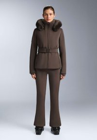 Hnedý, priliehavý sako s kožušinovým golierom, opasok v páse, dlhé rukávy, v páre s pasujúcimi priliehavými nohavicami a lesklými čiernymi topánkami. Hladká textúra.
