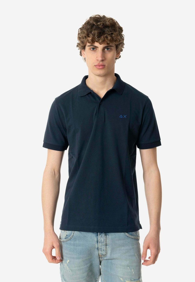 Polo shirt blu navy a maniche corte, con colletto classico e un piccolo logo blu sul petto sinistro. Realizzato in morbido cotone.
